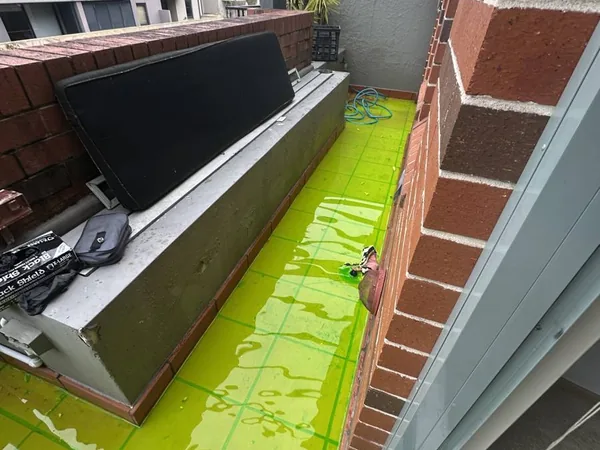 Green dye flood test holding water on a balcony