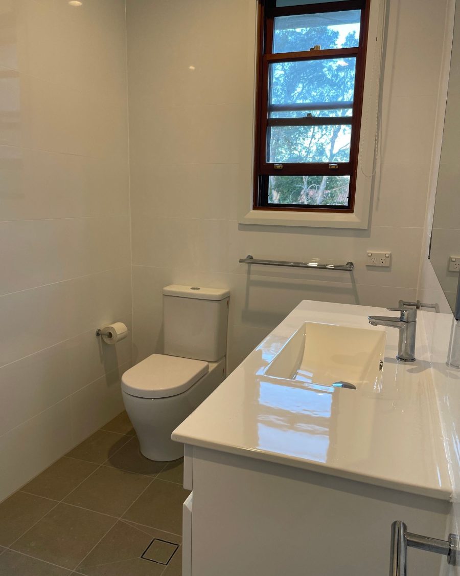 The same bathroom finished, with a new vanity, toilet and floor tiles